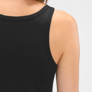 May include: Black sleeveless tank top with a scoop neck.