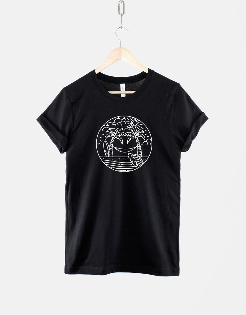 May include: Black t-shirt with a white graphic of palm trees, a hammock, and a surfboard in a circle.