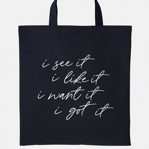 May include: Black tote bag with white text that reads "i see it i like it i want it i got it".