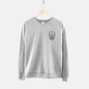 Puede incluir: Una sudadera gris con un dise&ntilde;o de calavera geom&eacute;trica negra en la parte delantera.