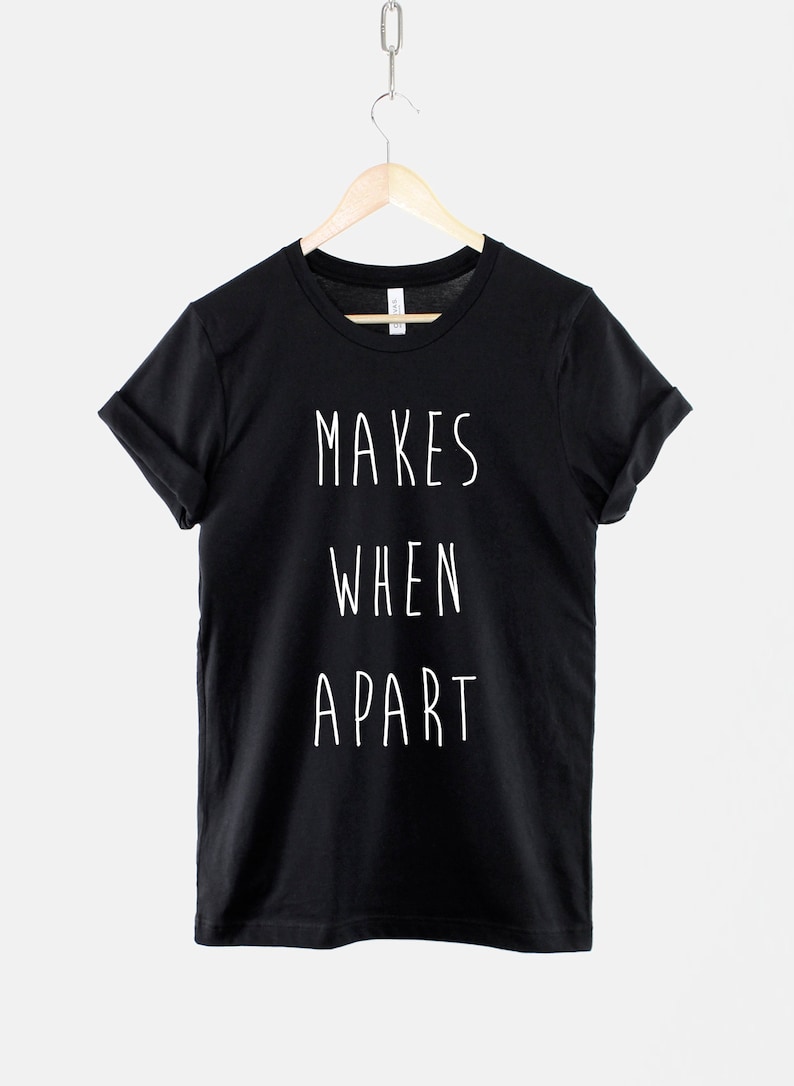 Puede incluir: Camiseta negra con texto blanco que dice "MAKES WHEN APART".