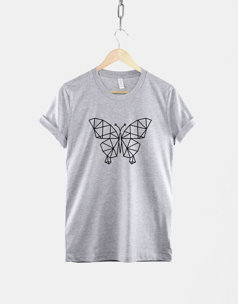 May include: A gray t-shirt with a geometric butterfly design printed in black on the front.