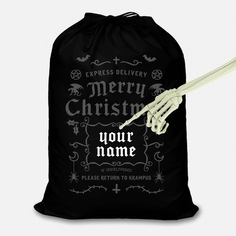 May include: Black Christmas gift bag with a spooky design featuring a skeleton hand pointing to a blank space for a name. The bag says "Express Delivery Merry Christmas your name If Undelivered Please Return to Krampus".