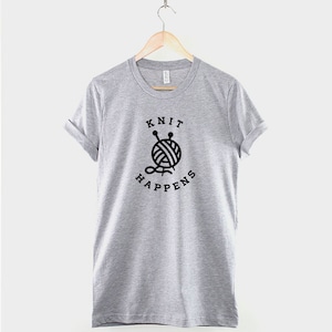 May include: Gray t-shirt with black text that reads "Knit Happens" and a graphic of a ball of yarn with knitting needles.