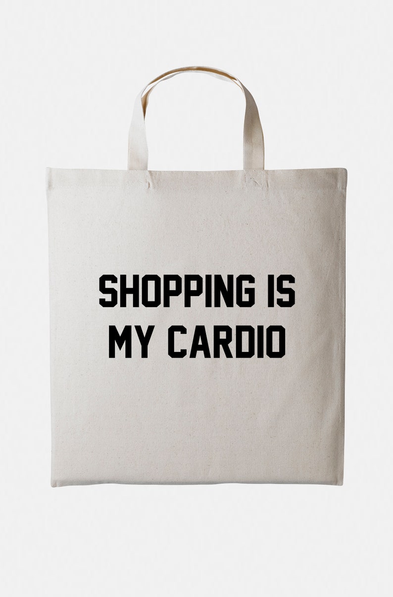 May include: A white canvas tote bag with black text that reads "SHOPPING IS MY CARDIO".