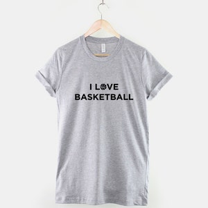 Puede incluir: Una camiseta gris con el texto "I LOVE BASKETBALL" y un gr&aacute;fico de baloncesto.
