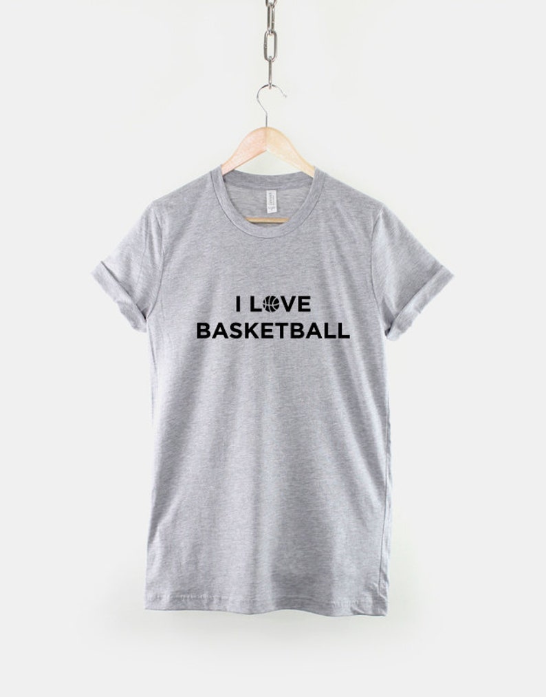 Puede incluir: Una camiseta gris con el texto "I LOVE BASKETBALL" y un gr&aacute;fico de baloncesto.
