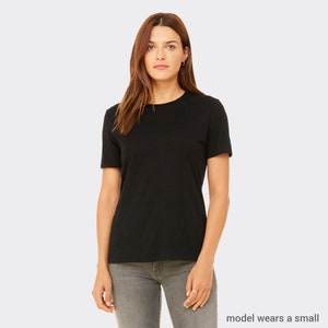 May include: A black short-sleeved t-shirt with a crew neck. The model is wearing a size small.