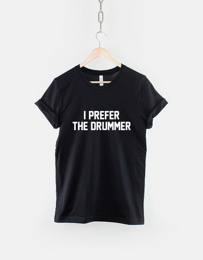 Puede incluir: Camiseta negra con texto blanco que dice "Prefiero al baterista".