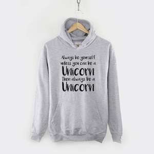 May include: A gray hooded sweatshirt with the text "Always be yourself unless you can be a Unicorn then always be a Unicorn" printed in black.