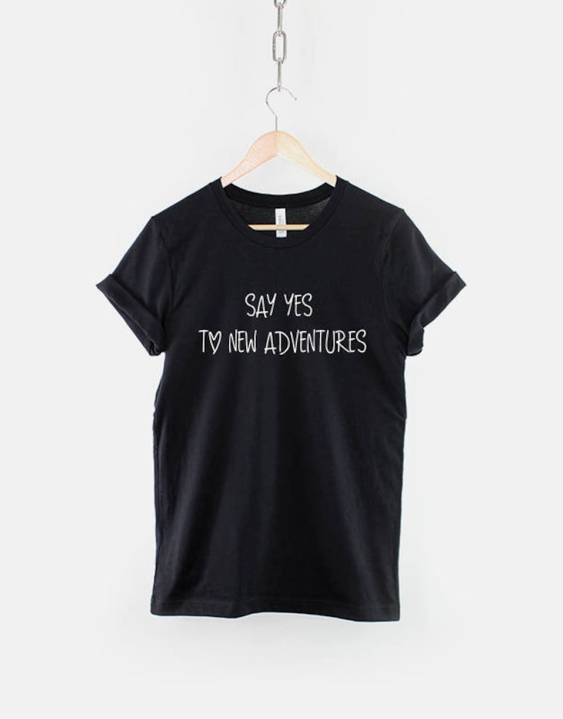 May include: Black t-shirt with white text that reads "Say yes to new adventures".