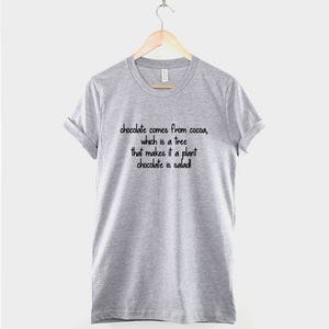 May include: A gray t-shirt with the text "chocolate comes from cocoa, which is a tree that makes it a plant chocolate is salad!" printed on the front.