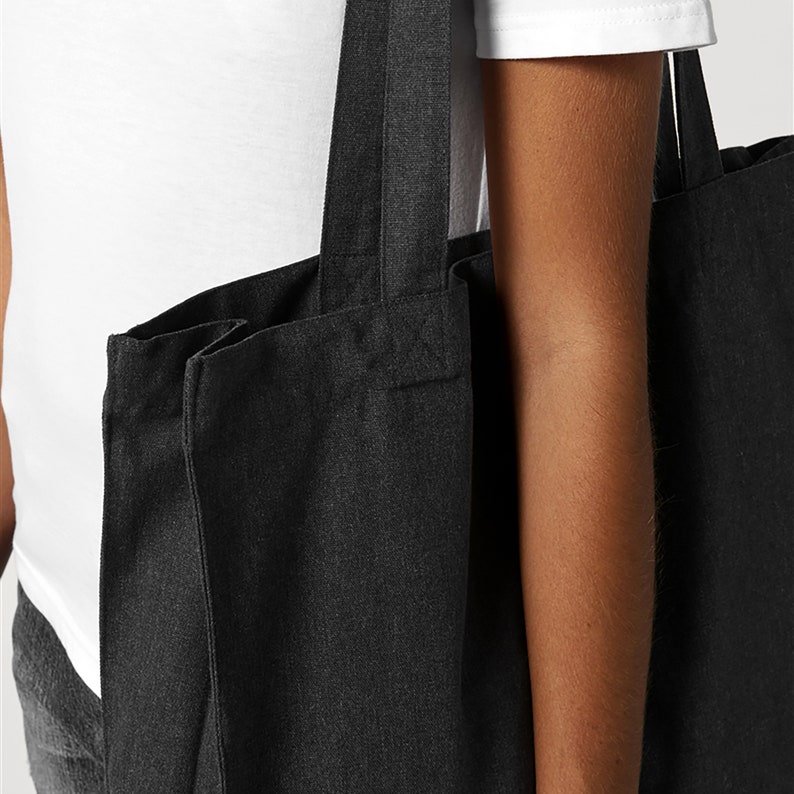 Puede incluir: Una bolsa de lona negra con dos asas largas. La bolsa est&aacute; hecha de una tela gruesa y resistente.