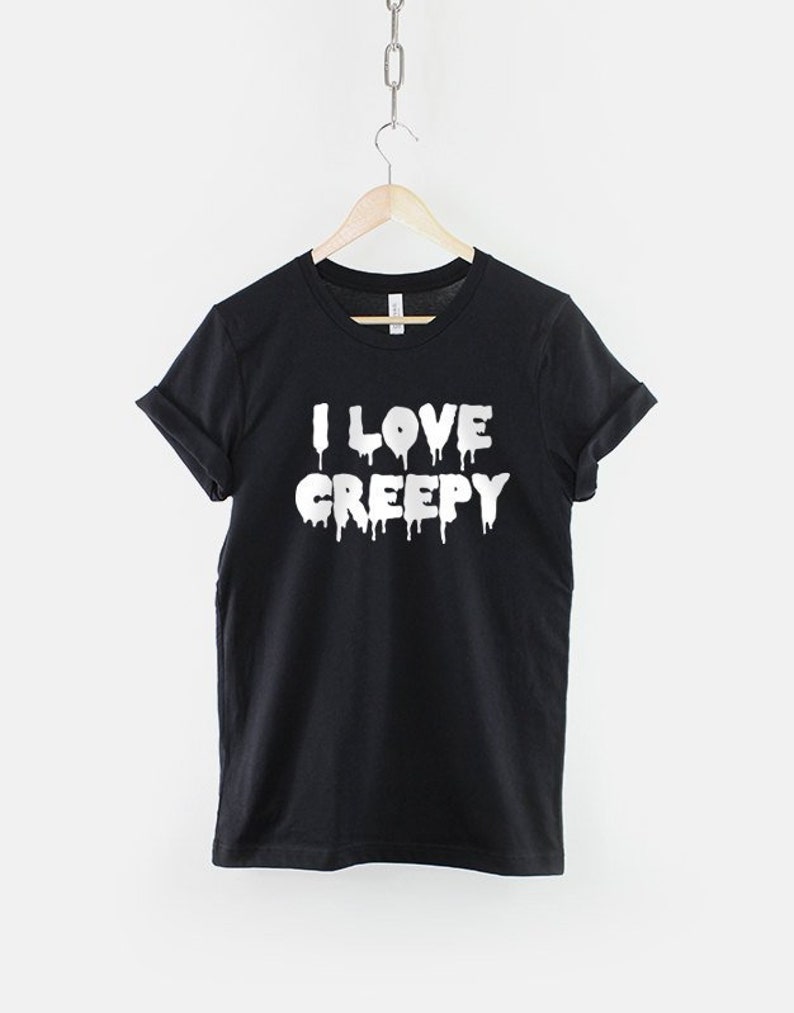 Puede incluir: Camiseta negra con texto blanco que gotea que dice "I LOVE CREEPY".
