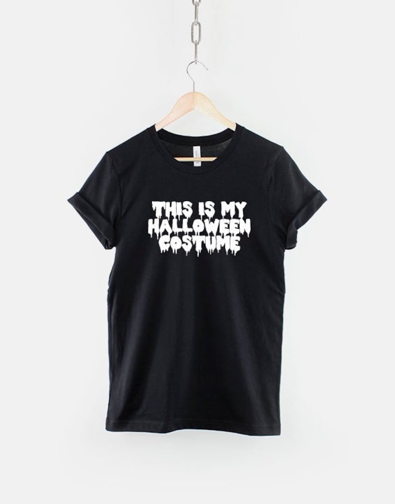 Puede incluir: Camiseta negra con texto blanco que dice "This is my Halloween Costume" con letras que gotean.