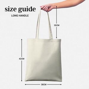 May include: A white canvas tote bag with long handles. The bag measures 38 cm wide, 42 cm tall, and the handles are 35 cm long. "Size Guide Long Handle" is printed on the bag.