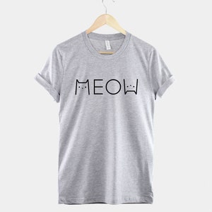 May include: A heather grey t-shirt with a black graphic of two cats and the word "MEOW" printed on the front.