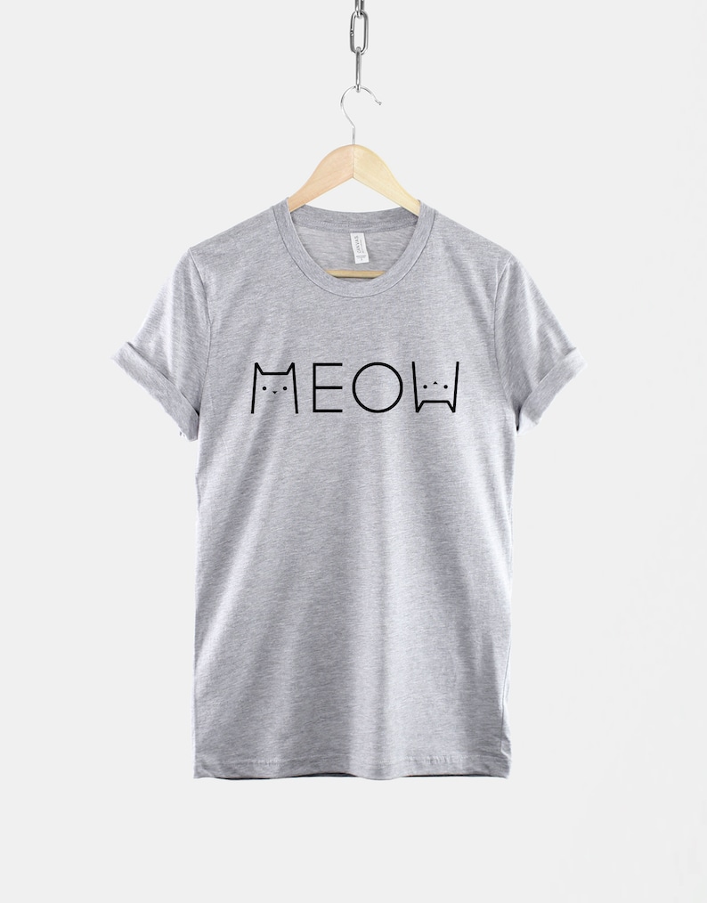 May include: A heather grey t-shirt with a black graphic of two cats and the word "MEOW" printed on the front.