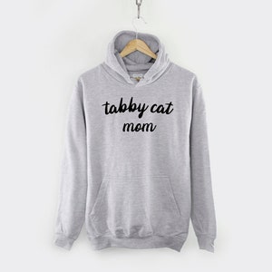 May include: Gray hooded sweatshirt with the text "tabby cat mom" in black lettering.