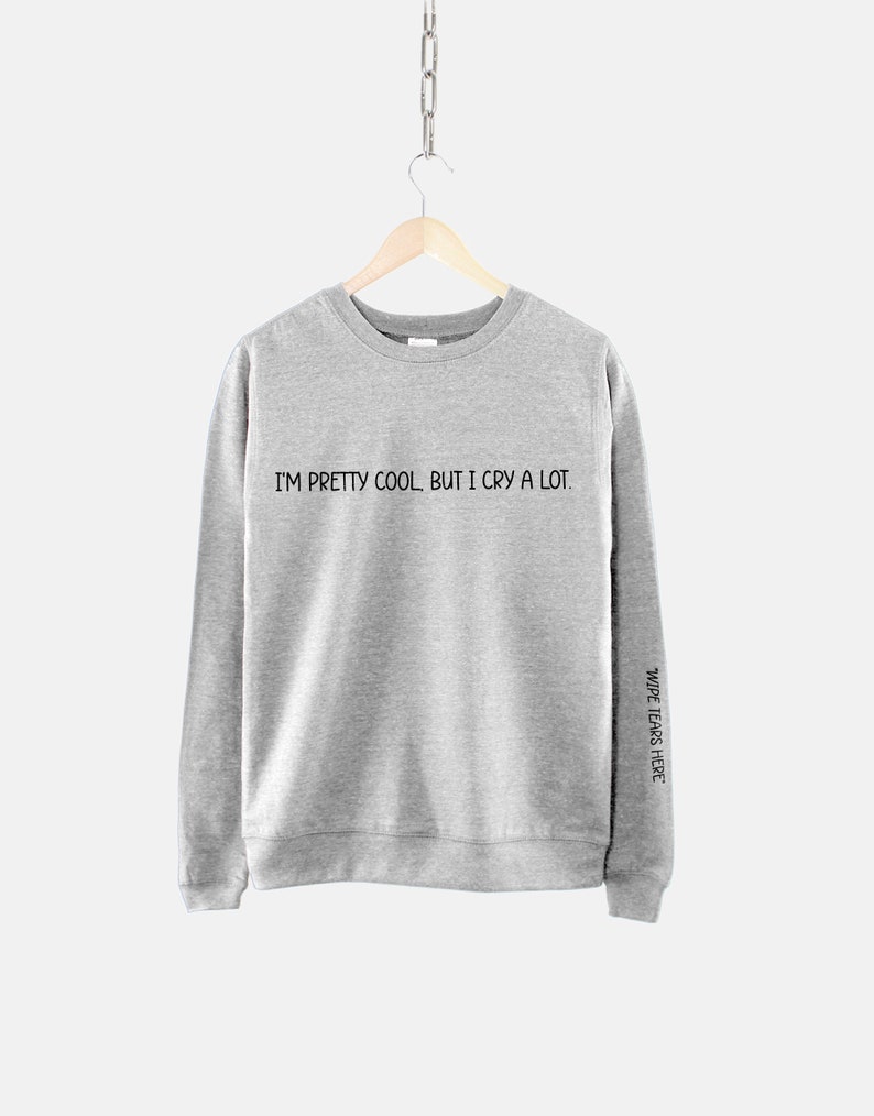 May include: Gray sweatshirt with the text "I'm pretty cool, but I cry a lot." printed on the front and "Wide tears here" printed on the right sleeve.