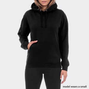May include: Black hooded sweatshirt with a pouch pocket. The model is wearing a small size.