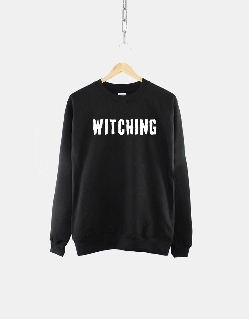 May include: Black sweatshirt with the word "Witching" printed in white on the front.