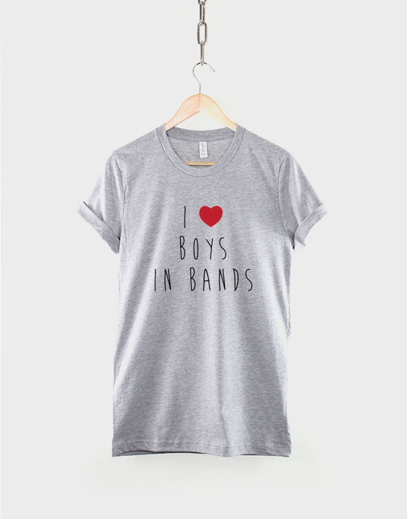 May include: A heather grey t-shirt with a red heart and the text "I &hearts; BOYS IN BANDS" printed on the front.