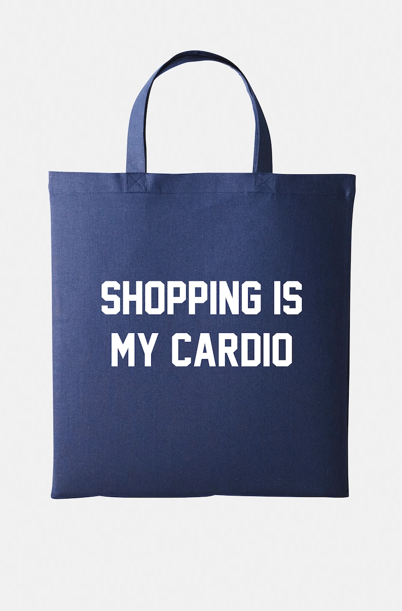May include: A navy blue tote bag with white text that reads "SHOPPING IS MY CARDIO".