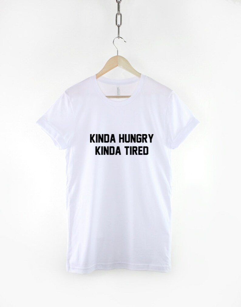 K&ouml;nnte beinhalten: Wei&szlig;es T-Shirt mit schwarzem Text, der "Kinda Hungry Kinda Tired" lautet.