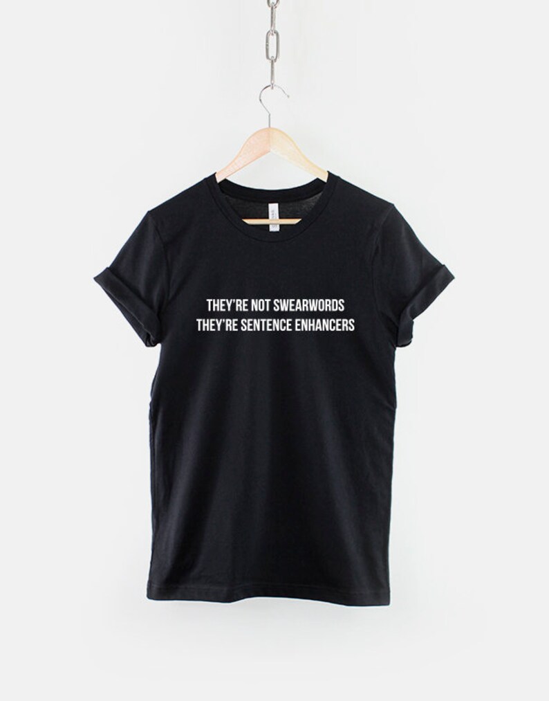 Puede incluir: Camiseta negra con texto blanco que dice "They're not swearwords They're sentence enhancers".