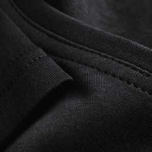 May include: Close-up of black fabric with a seam running along the edge.