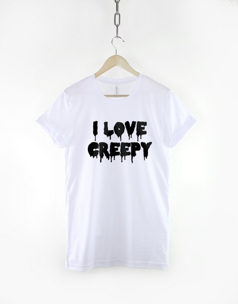 Puede incluir: Camiseta blanca con texto negro que gotea y dice "I LOVE CREEPY".