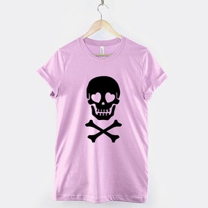 May include: A pink t-shirt with a black skull and crossbones design. The skull has hearts for eyes.