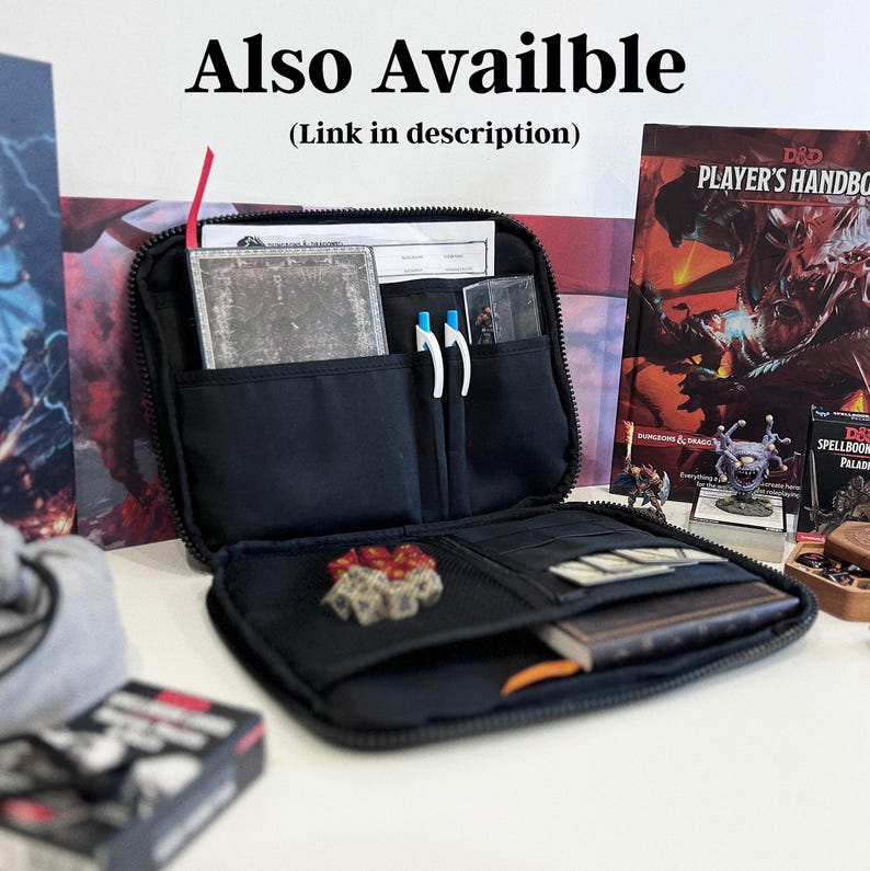 May include: A black zipped organiser case containing a notebook, two pens, a set of polyhedral dice, and various gaming cards. The interior features multiple pockets and compartments for storage. Text at the top reads Also Availble (Link in description).