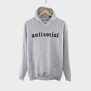 K&ouml;nnte beinhalten: Ein grauer Kapuzenpullover mit einem schwarzen Aufdruck, der in gotischer Schrift "antisocial" lautet.