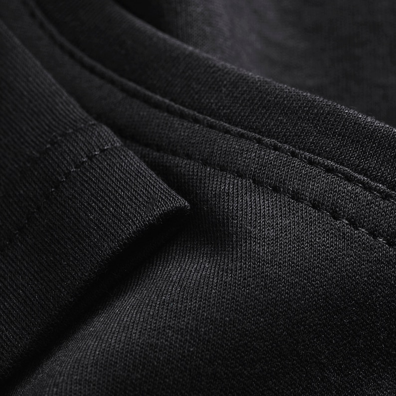 May include: Close-up of black fabric with a subtle texture and a single seam running along the edge.