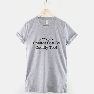 May include: Gray t-shirt with a black snake graphic and the text "Snakes Can Be Cuddly Too!"