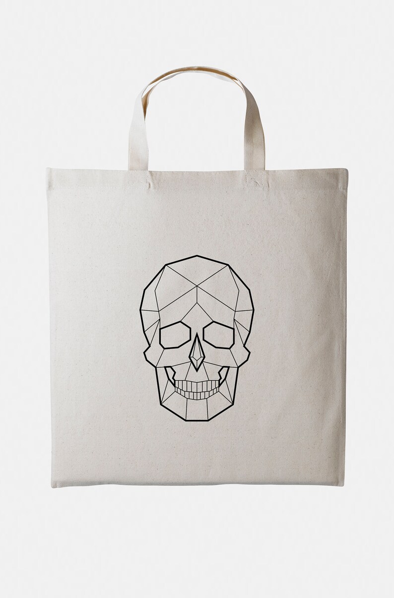 May include: A white canvas tote bag with a geometric skull design printed in black.