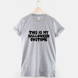 Puede incluir: Camiseta gris con texto negro que dice "This is my Halloween costume" con las letras goteando.