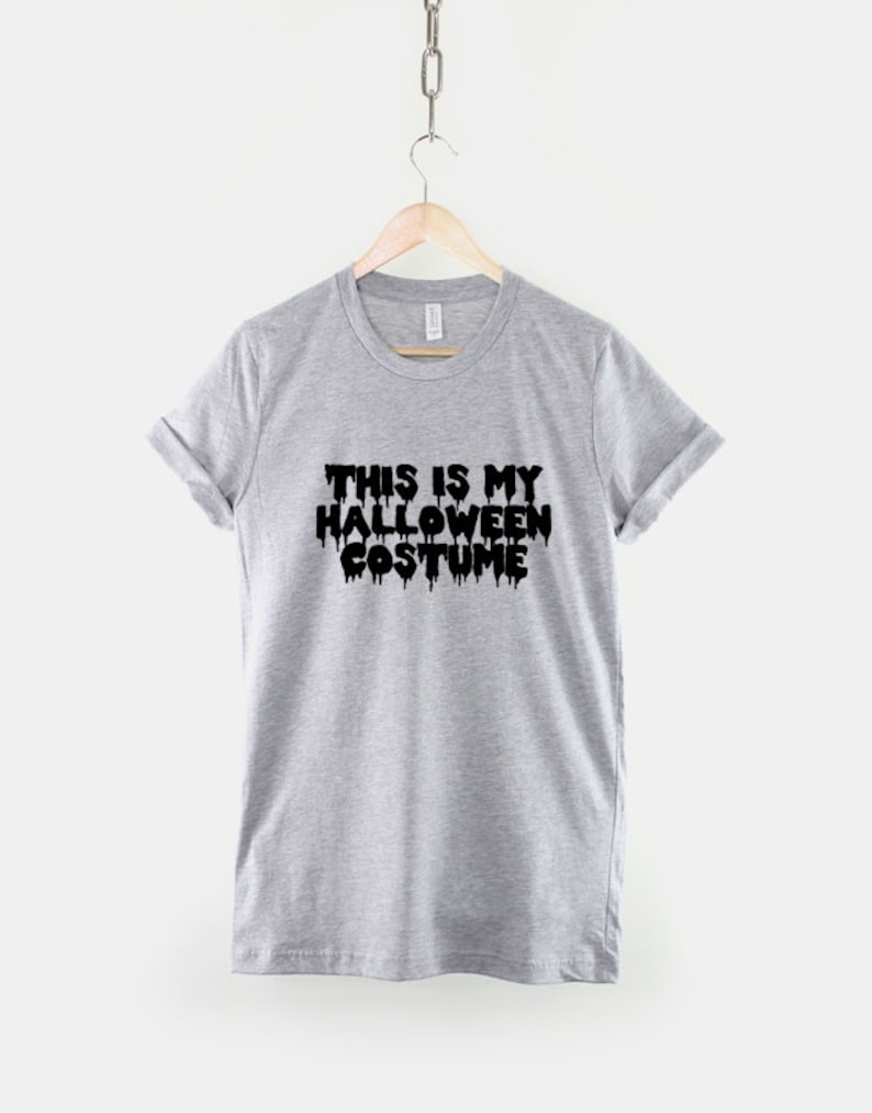 Puede incluir: Camiseta gris con texto negro que dice "This is my Halloween costume" con las letras goteando.