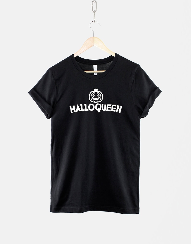 Peut inclure: T-shirt noir avec un graphique blanc d'une citrouille avec une couronne et le texte "Halloqueen".