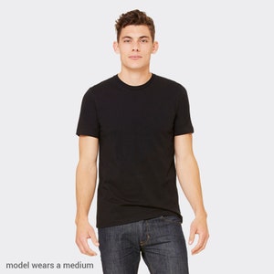 Peut inclure: Un t-shirt noir &agrave; manches courtes avec un col rond. Le mod&egrave;le porte une taille moyenne.
