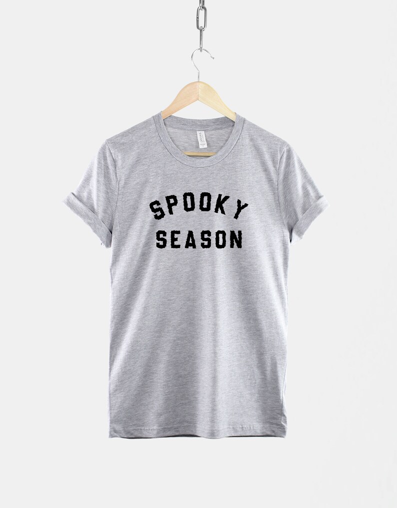 Puede incluir: Una camiseta gris jaspeada con texto negro que dice "Spooky Season".