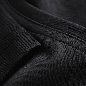 May include: Close-up of black fabric with a stitched seam. The fabric has a textured, woven appearance.