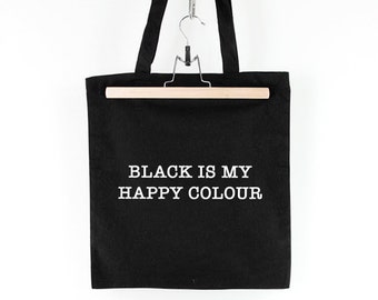 May include: Black canvas tote bag with white text that reads "BLACK IS MY HAPPY COLOUR".