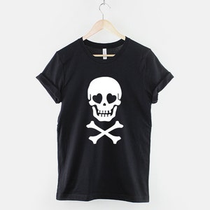 May include: Black t-shirt with a white skull and crossbones design. The skull has heart-shaped eyes.