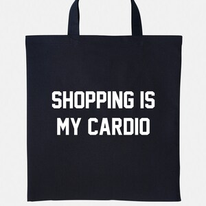 May include: Black canvas tote bag with white text that reads "Shopping is my cardio."