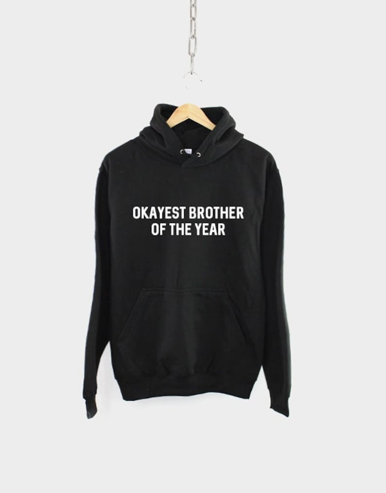 May include: Black hooded sweatshirt with the text "Okayest Brother of the Year" in white.
