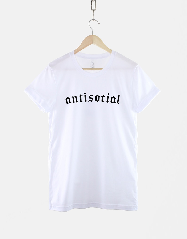 May include: White t-shirt with black gothic lettering that reads "antisocial".