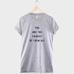 May include: A heather gray t-shirt with black text that reads "You are the fairest of them all".